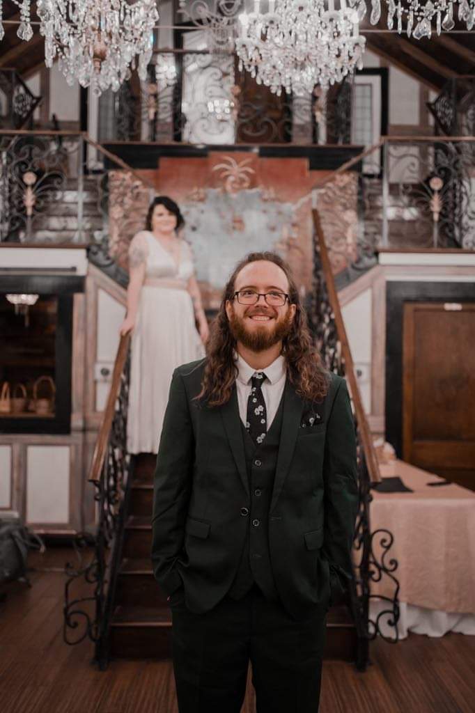 A wedding photo of Blake Gambel, founder of Gambel Labs IT Consulting, at their wedding. Their wife is visible in the background, and she is stunning.